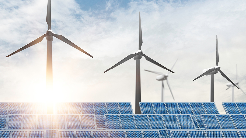 Windmills behind solar panels